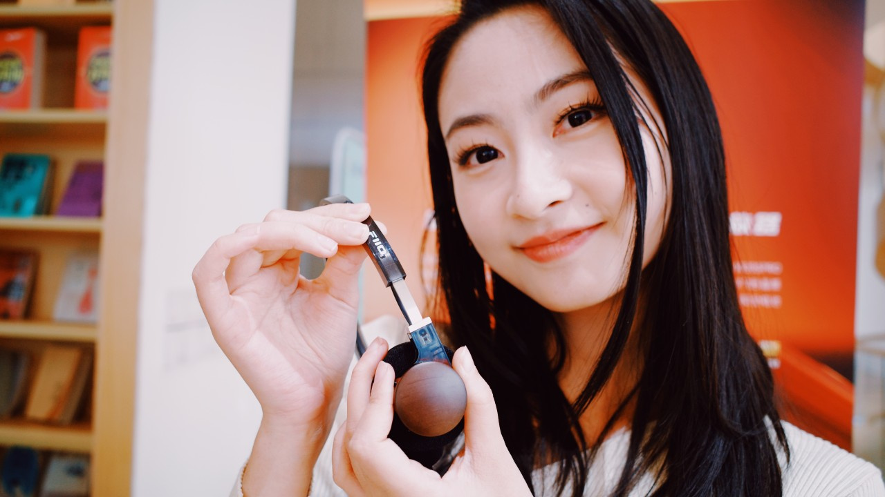 Fone de ouvido Bluetooth FiiO EH11 sendo segurado por uma mulher.